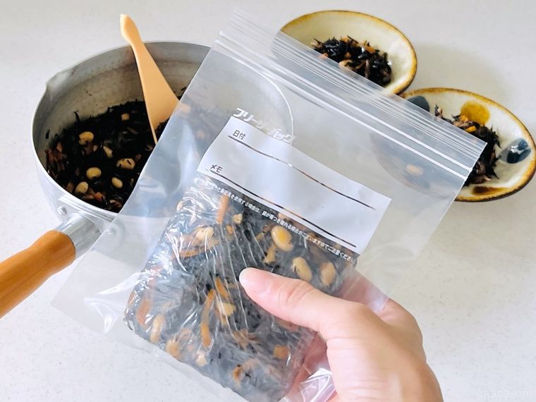 ひじきの煮物が入った保存袋を手で持っている様子