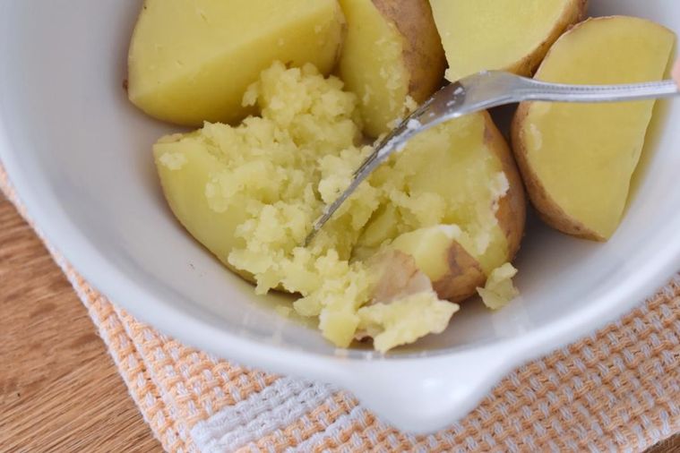 ボウルの中でフォークで砕いたじゃがいも
