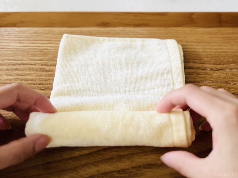 濡れたハンドタオルをクルクルと巻いている様子