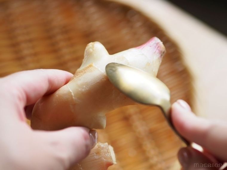 スプーンで新生姜の皮をこする様子