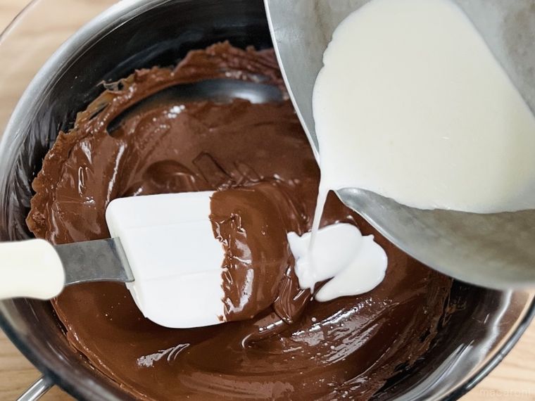 溶かしたチョコレートに温めた生クリームを加えている様子