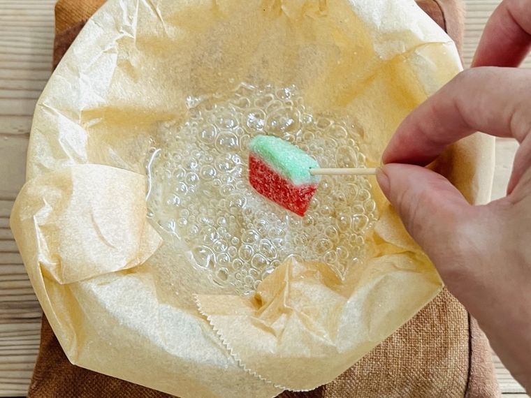 溶かした飴にグミをくぐらせている様子