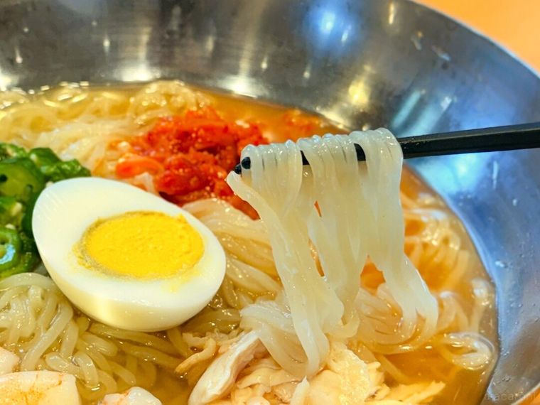 「海老と蒸し鶏のコク旨冷麺」を箸で持っている様子