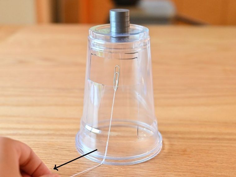 糸を引いてクリップの位置を調整している