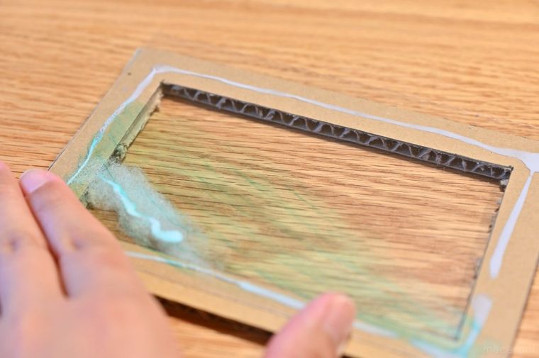 ダンボール枠に透明板を貼り付けている
