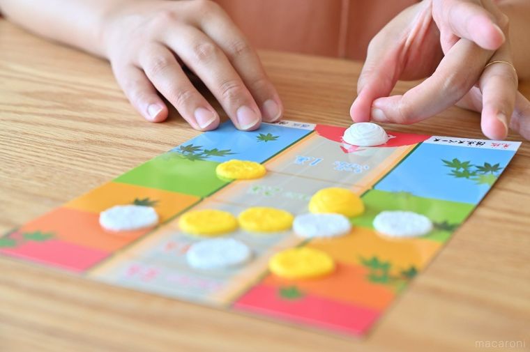 台紙の上にある白いパーツを指ではじこうとしている