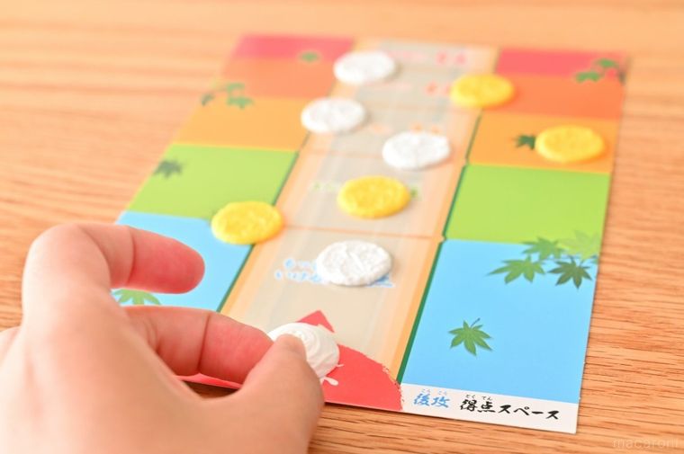 ボードゲームのパーツを指ではじこうとしている