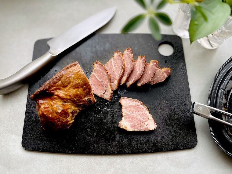 コストコ広東風チャーシューを黒いカッティングボードの上でスライスしているところ