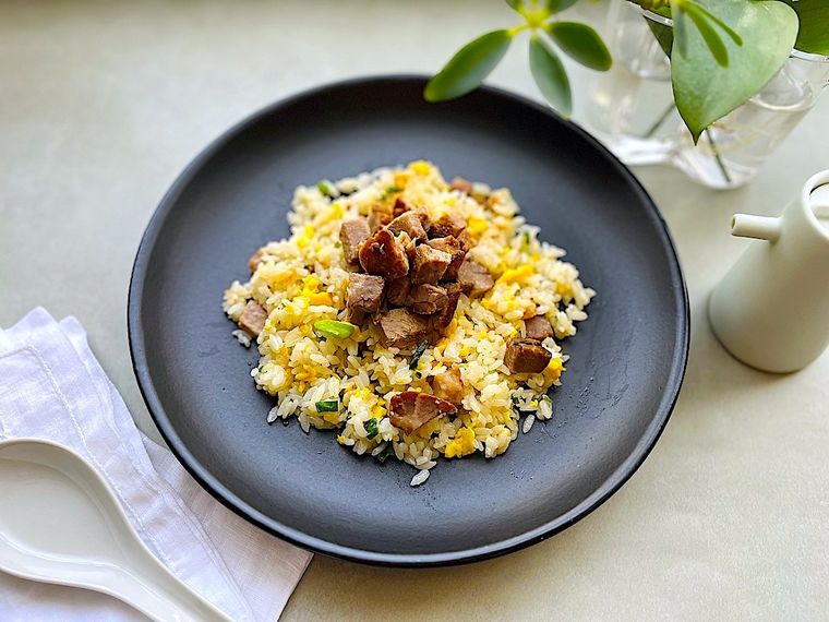 黒い皿に盛り付けたコストコ広東風チャーシュー入りのチャーハン、れんげ、お酢の小瓶