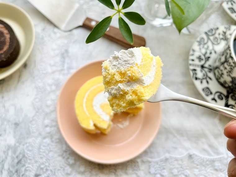 ピンク色のケーキ皿にのったコストコの米粉のスイスロールを、ひと口分フォークに取ったところ