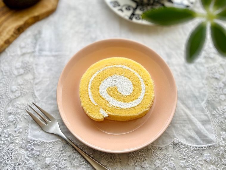 カットしたコストコの米粉のスイスロールを、ピンク色のケーキ皿にのせたところ