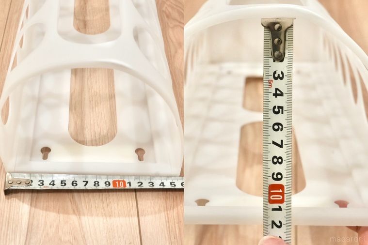 丸い穴が開いた白いプラスチック製の袋ディスペンサーをメジャーで測る様子