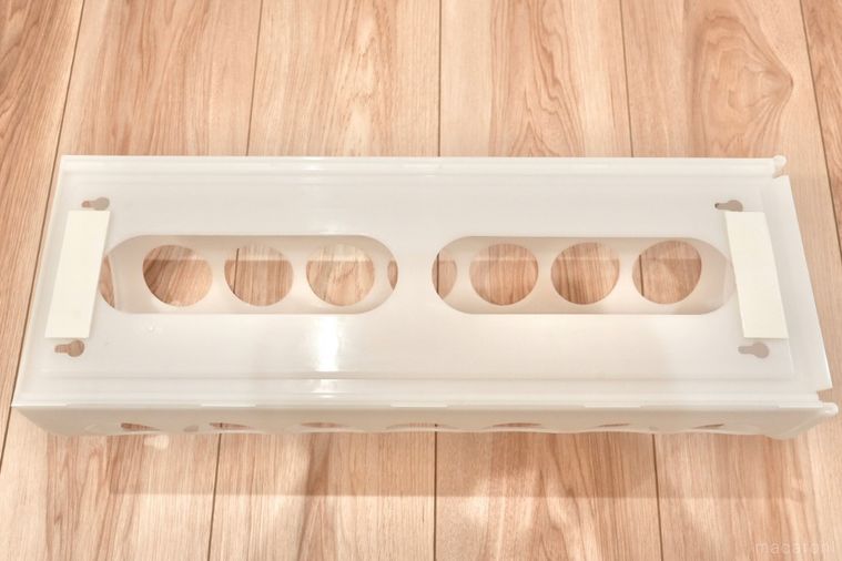 丸い穴が開いた白いプラスチック製の袋ディスペンサーの取り付け面