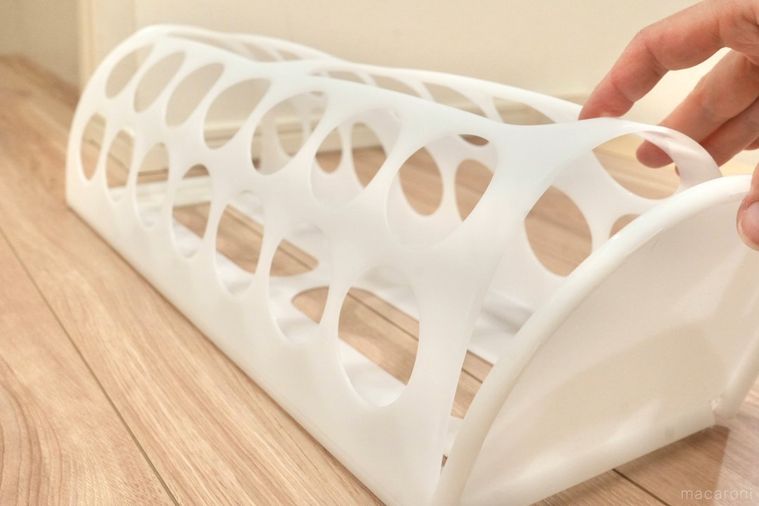 丸い穴が開いた白いプラスチック製の袋ディスペンサーを組み立てる様子