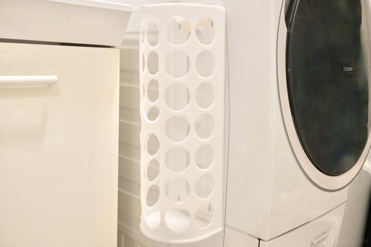 白い洗濯機の側面に取り付けられた丸い穴の空いた白色のディスペンサー