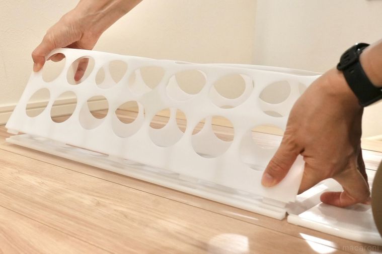 白いプラスチック製の袋ディスペンサーを組み立てる様子