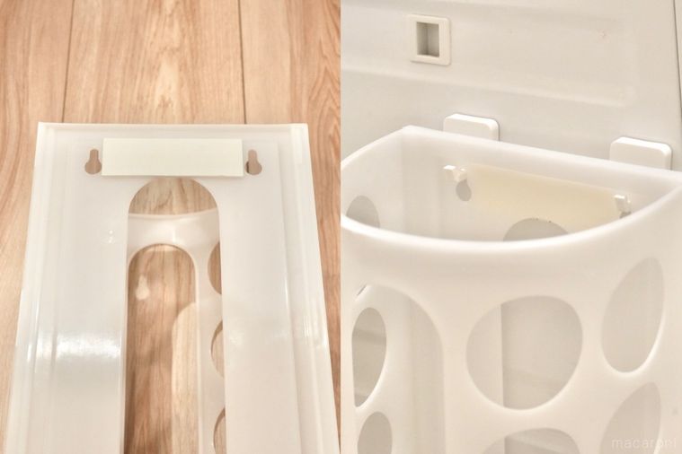 丸い穴が開いた白いプラスチック製の袋ディスペンサーを白いマグネットフックで洗濯機に固定する様子