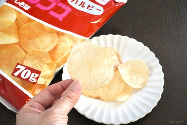 白い器に盛られたポテトチップスと赤色とピンク色のパッケージ