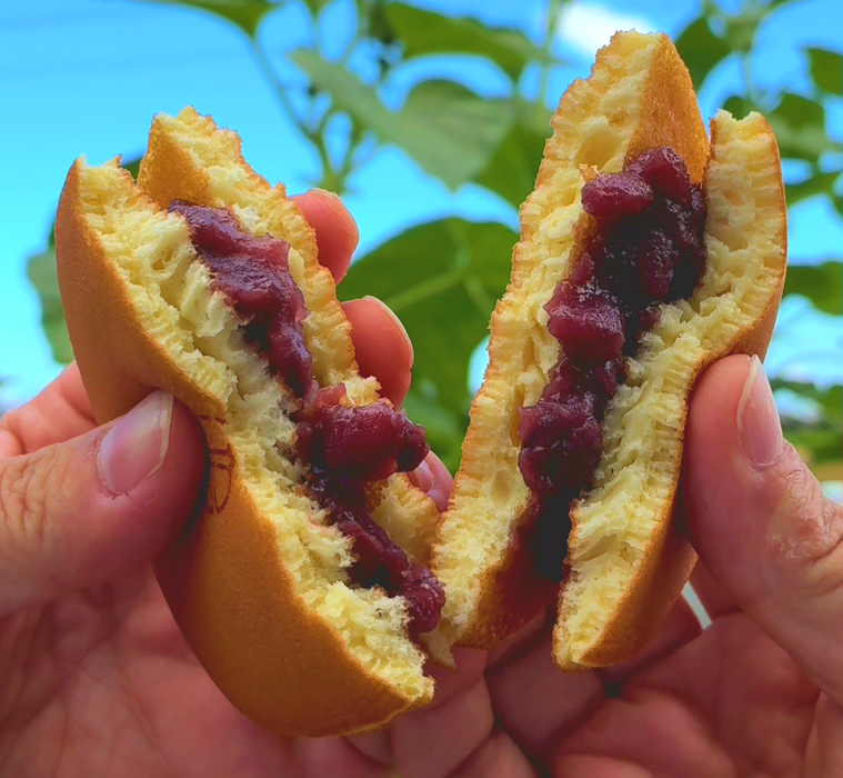 手で半分に割られたどら焼きのアップ