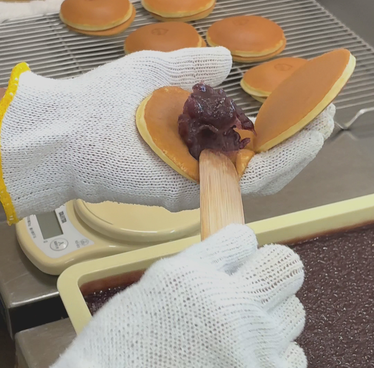 皮にあんこを挟んでいるところ