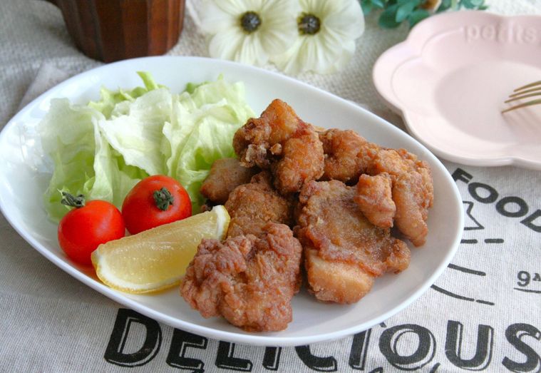 白い皿にモチコチキンやレタス、ミニトマト、カットレモンが盛られている様子