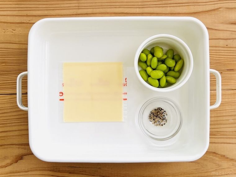 バットの上にスライスチーズ、むき枝豆、粗挽き黒こしょうが置かれている