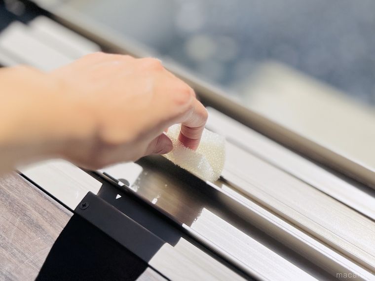 キッチンシートスポンジで窓のサッシを掃除している様子