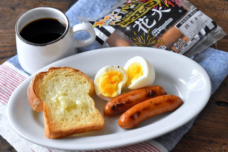 皿に盛ったパン、ゆで卵、ソーセージとコーヒー、シャウエッセンのパッケージ