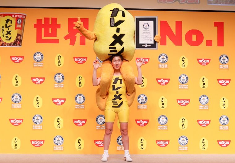 元レスリング選手の吉田沙保里さんが、ギネス認定証を持ったカレーメシくんを肩車している