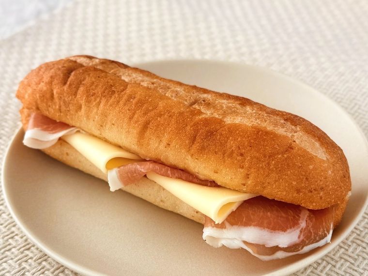 パンにジャンボンフーズ トリュフ香るロース生ハム 35gを挟んでいる様子