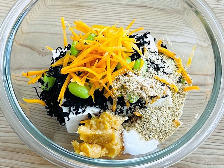 ボウルに豆腐、乾燥ひじき、枝豆、にんじん、調味料を入れた様子