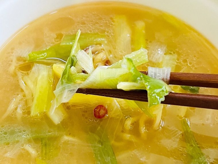 カップラーメンにトッピングされたねぎを箸で持ち上げている様子