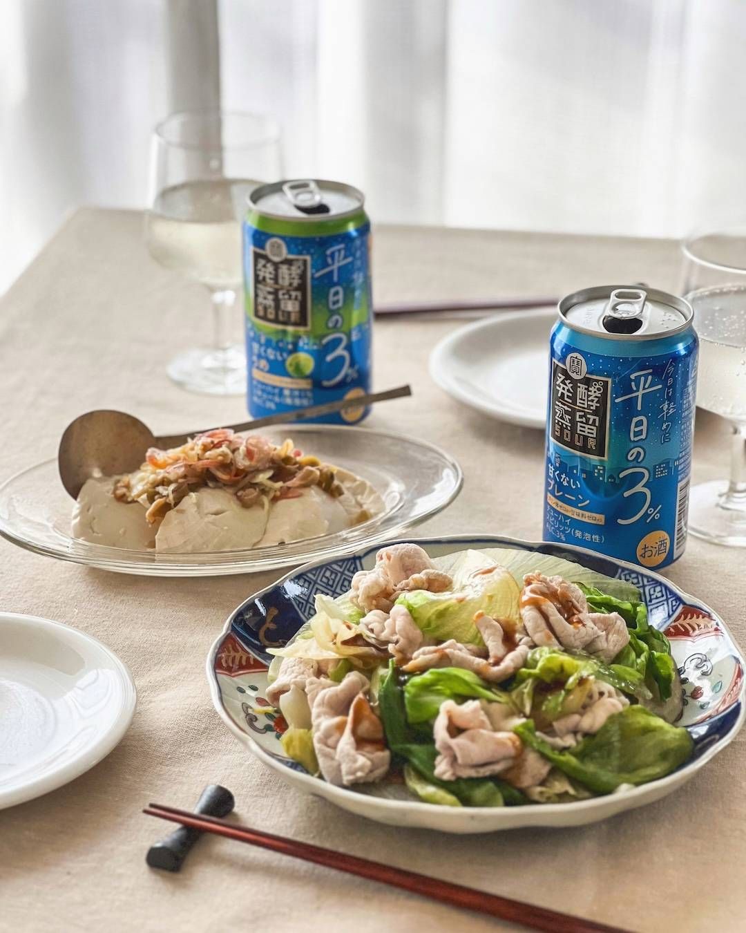 発酵蒸留サワー平日の３と大皿に盛られた料理が並ぶ食卓。