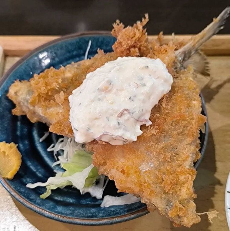 青いお皿に盛られた鯖の黒煮あじフライ定食のアジフライ