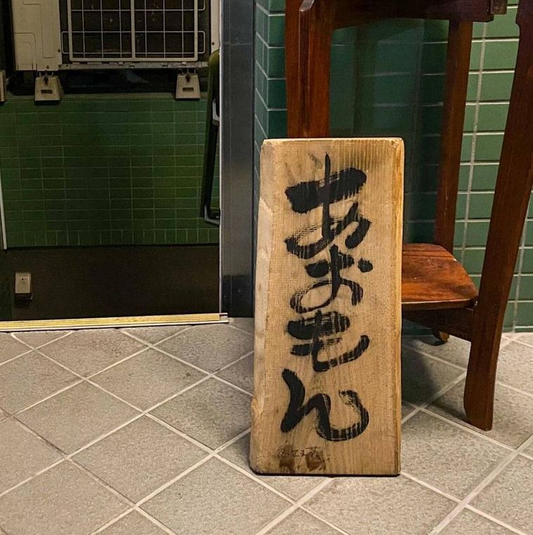 木の店名入り看板が置かれた酒肴あおもんの外観