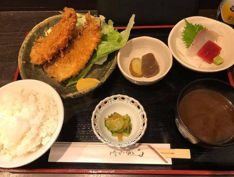 黒いトレイにのせられたアジフライ定食