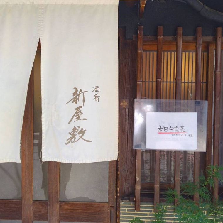 白いのれんがかかった酒肴 新屋敷の外観