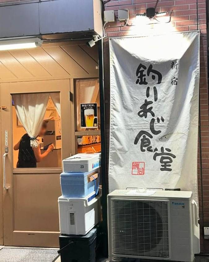 店名が書かれた白い店頭幕のある釣りあじ食堂の外観