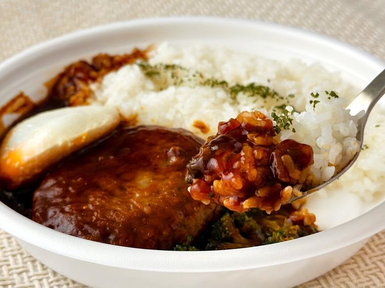 「Kona's Coffee監修 グレイビーソースとビーフハンバーグのロコモコ」をスプーンですくっている様子