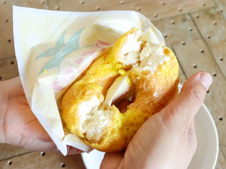 ビアードパパのパインアメシューを手で半分に割っている様子