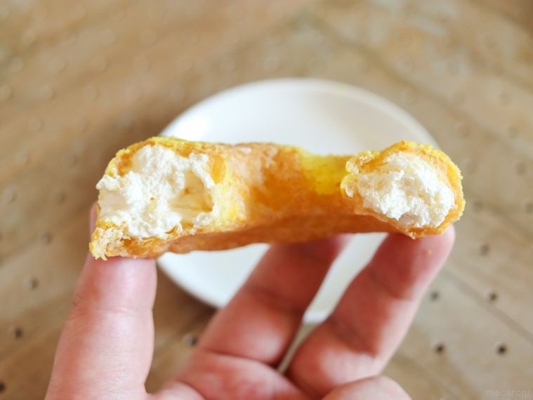 半分に割ったビアードパパのパインアメシューを片手で持っている