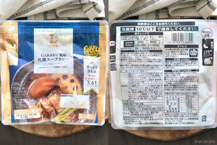 木のカッティングボードにのった青色と金色のパッケージのレトルトスープカレーとパッケージ裏面の原材料表示と生成色の布