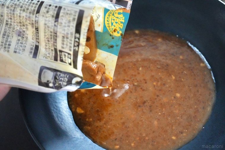 レトルトスープカレーの袋の中身を黒い器に出す様子