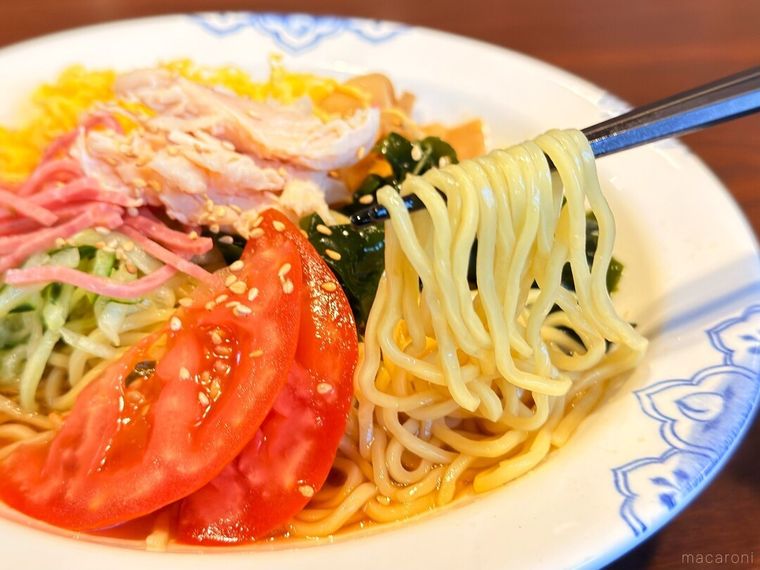 蒸し鶏五目冷やし中華醤油を箸で持っている様子