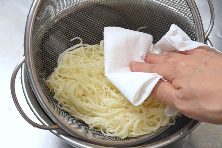 キッチンペーパーをそえたざるの中のそうめん