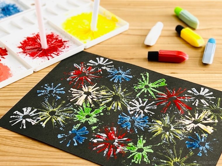 花火の絵が描かれた黒い画用紙と、絵の具とパレット