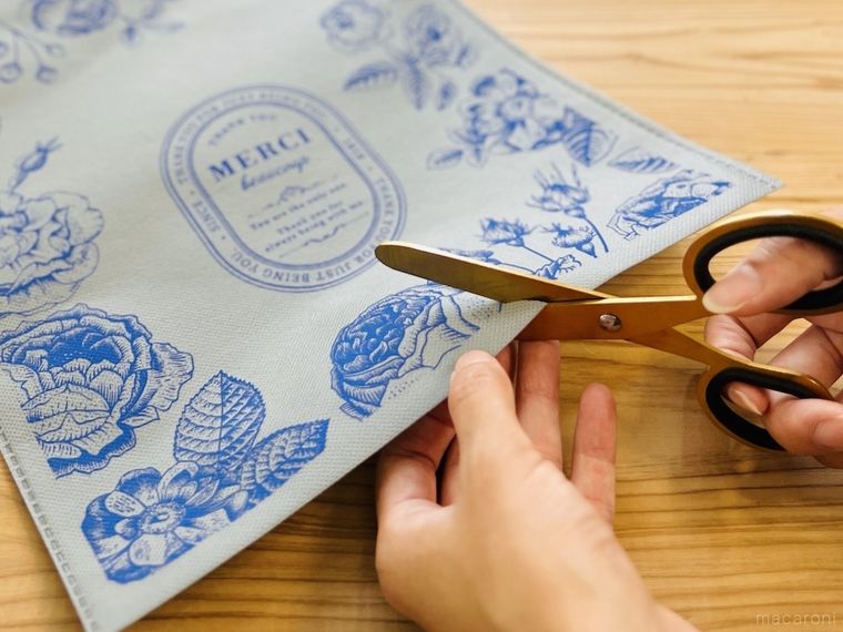 不織布の袋の底をハサミで切り取っている様子