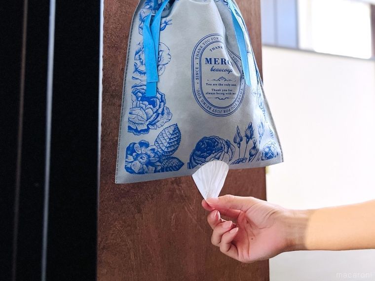 不織布の袋の底から、スーパーのレジ袋を引っ張り出している様子