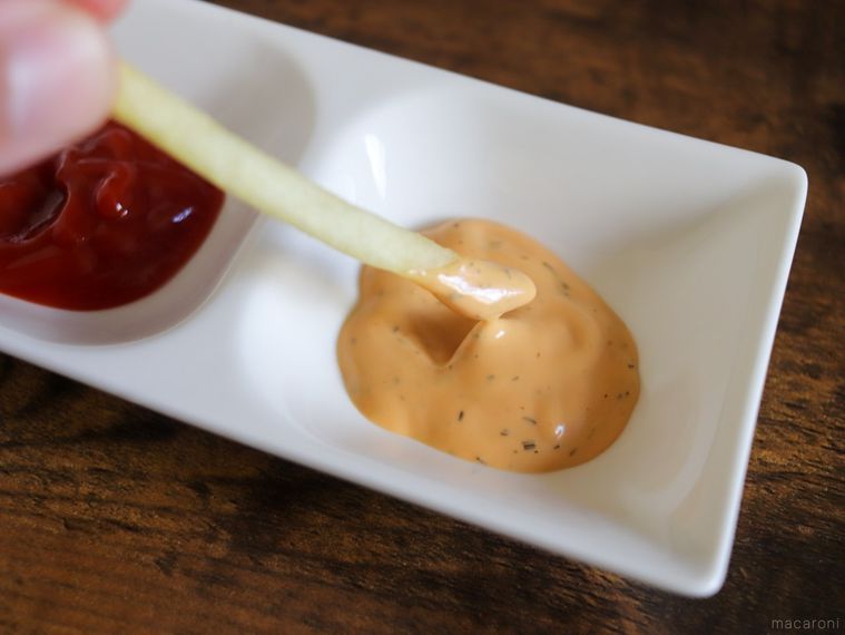 調理したポッポのポテトを1本手に取り、バーベキューマヨネーズに付けている様子