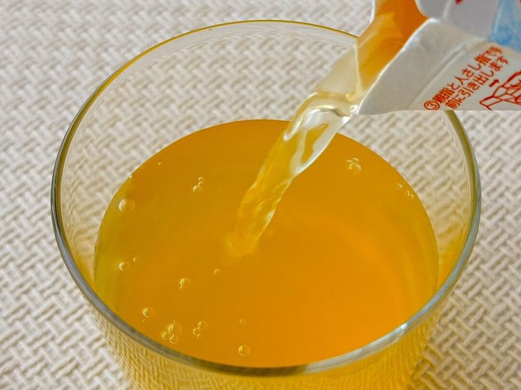 冷凍みかんはじめました 450mlをグラスに注いでいる様子